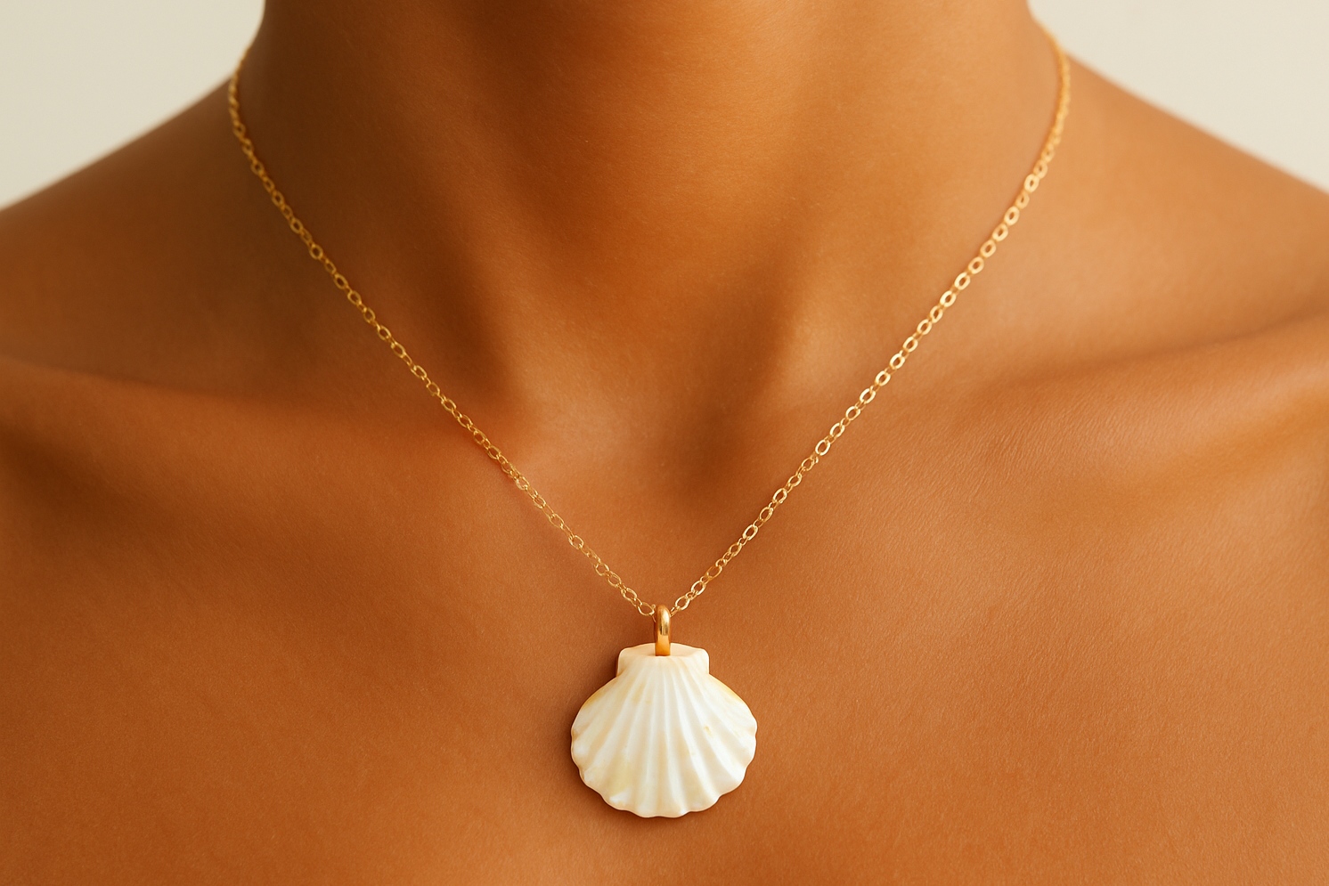 Shell Necklace with gold chain on tan female skin. 